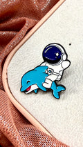Pin astronauta y delfín