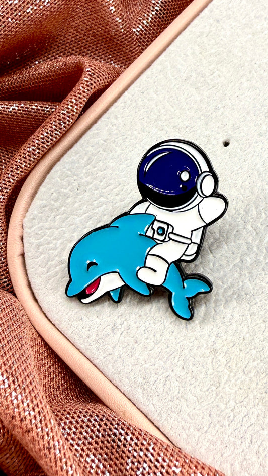 Pin astronauta y delfín